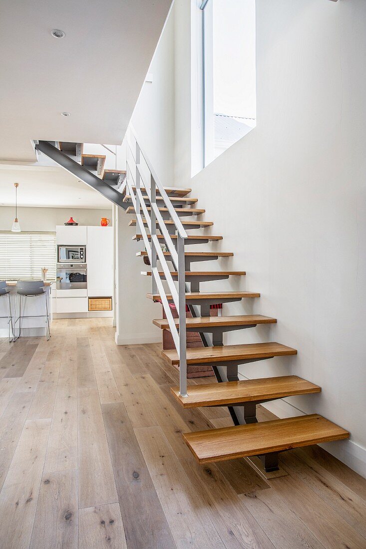 Moderne Treppe mit Holzstufen im modernen Wohnraum mit Küche