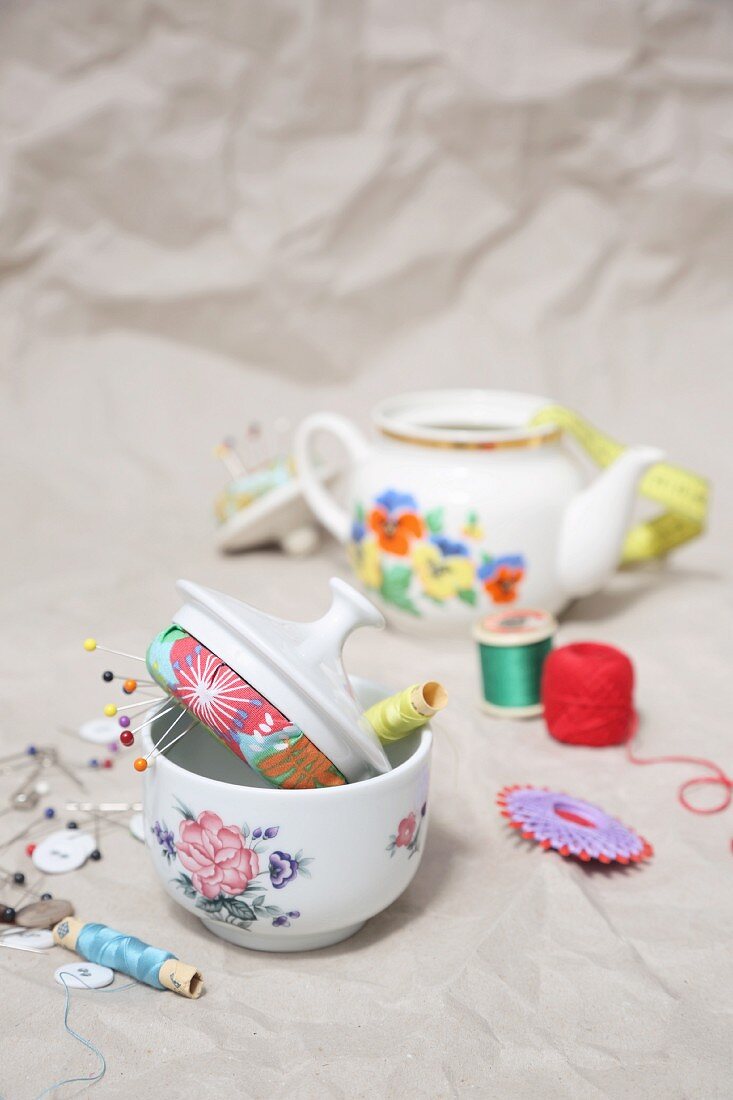 Sewing supplies in old teapot and sugar bowl