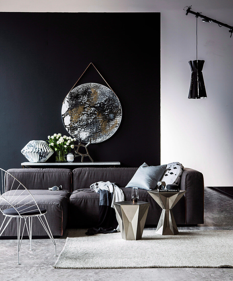Stuhl, silberne Beistelltische und Sofa vor Konsolentisch mit Skulptur aus Marmorpapier und Tulpenstrauß, rundesKunstwerk in Metallic-Optik