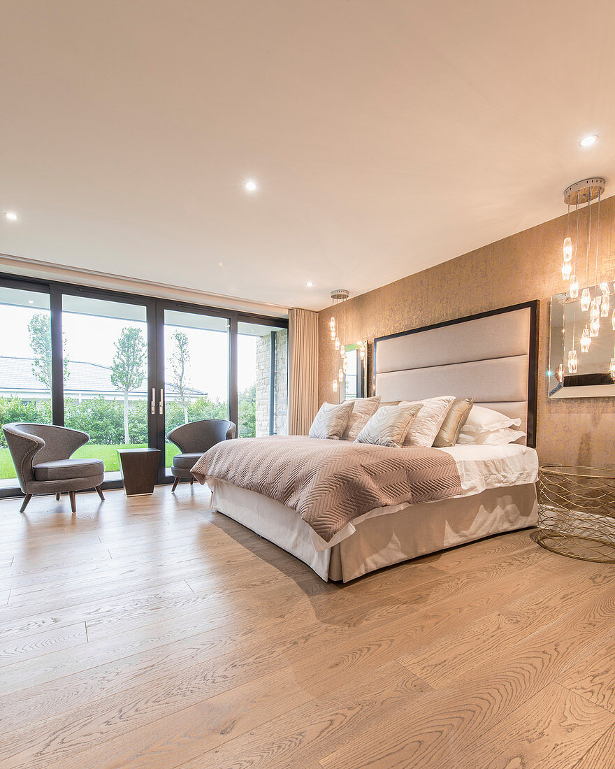 Glamorous bedroom in gold and beige with wooden floor