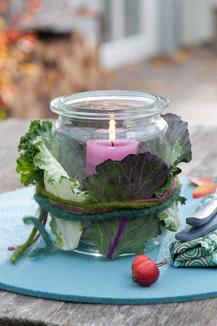 Preserving jar as a lantern clad with Brassica leaves
