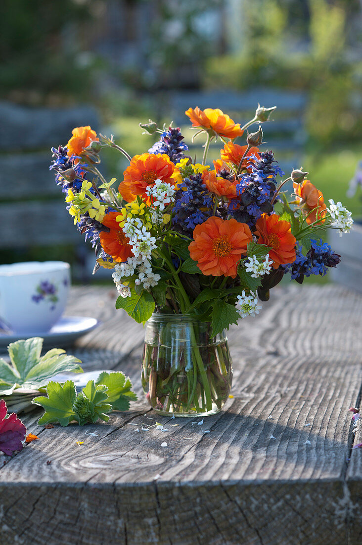 Colorful spring bouquet with geum, ajuga, alliaria