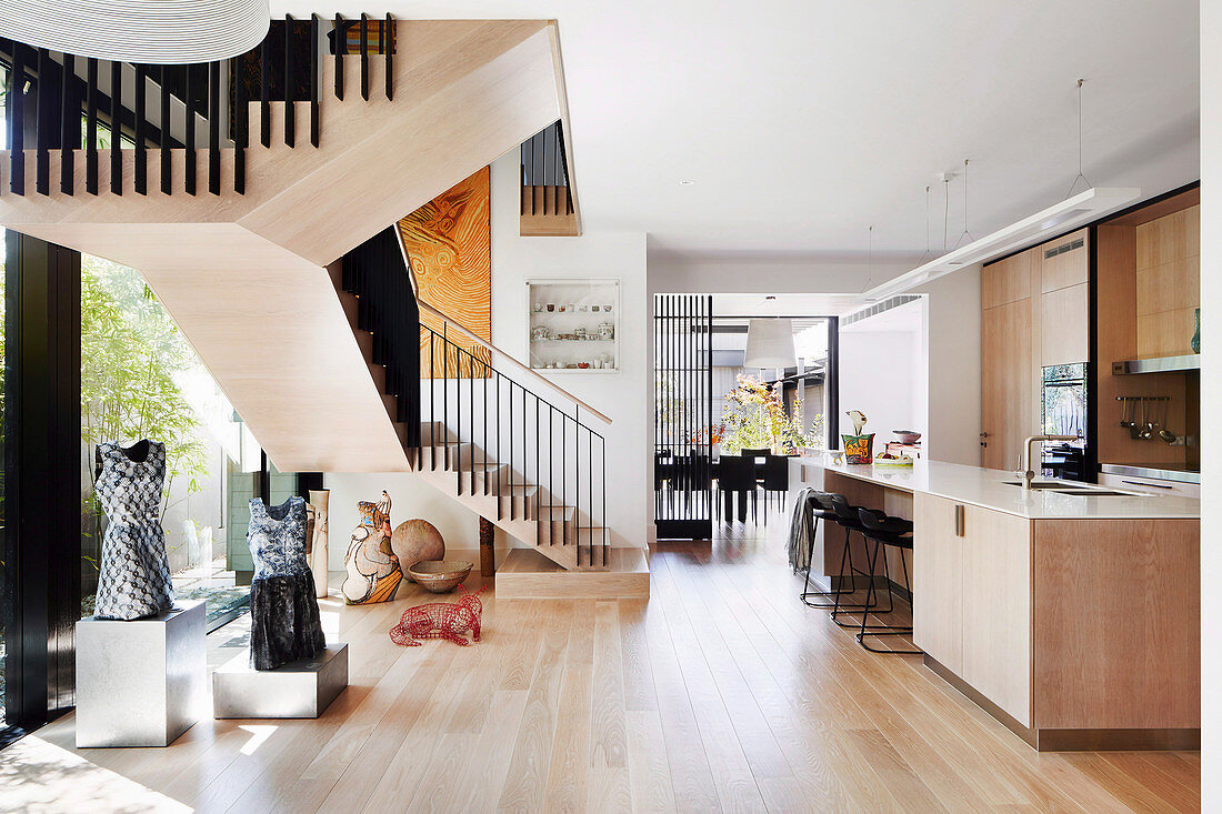 Moderner offener Wohnraum mit hellem Holz und Kunstobjekten