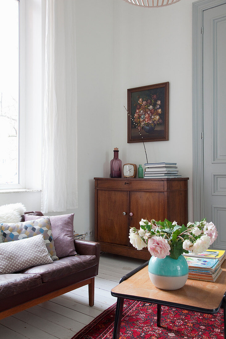 Vase of roses on coffee table in vintage-style living room