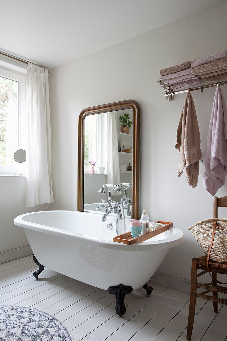 Large mirror behind free-standing bathtub