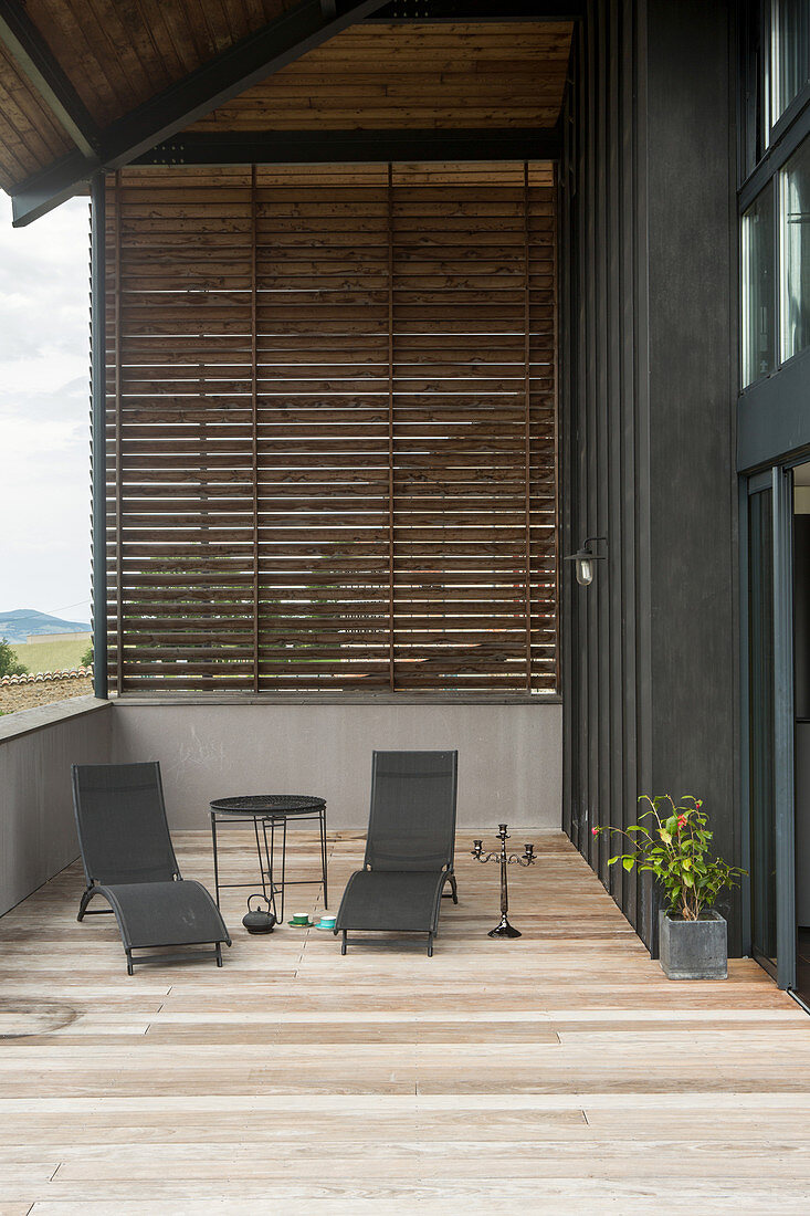 Zwei Liegestühle auf der überdachten Terrasse