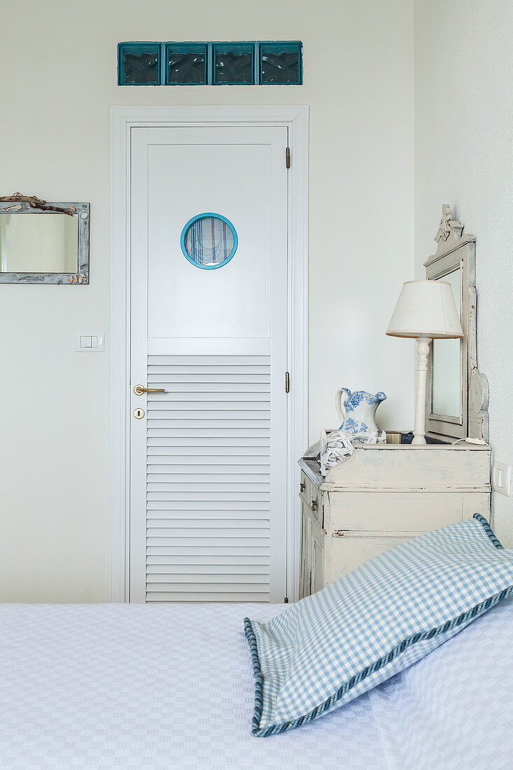 Tür mit Bullauge und Oberlichtern aus Glasbausteinen im Schlafzimmer