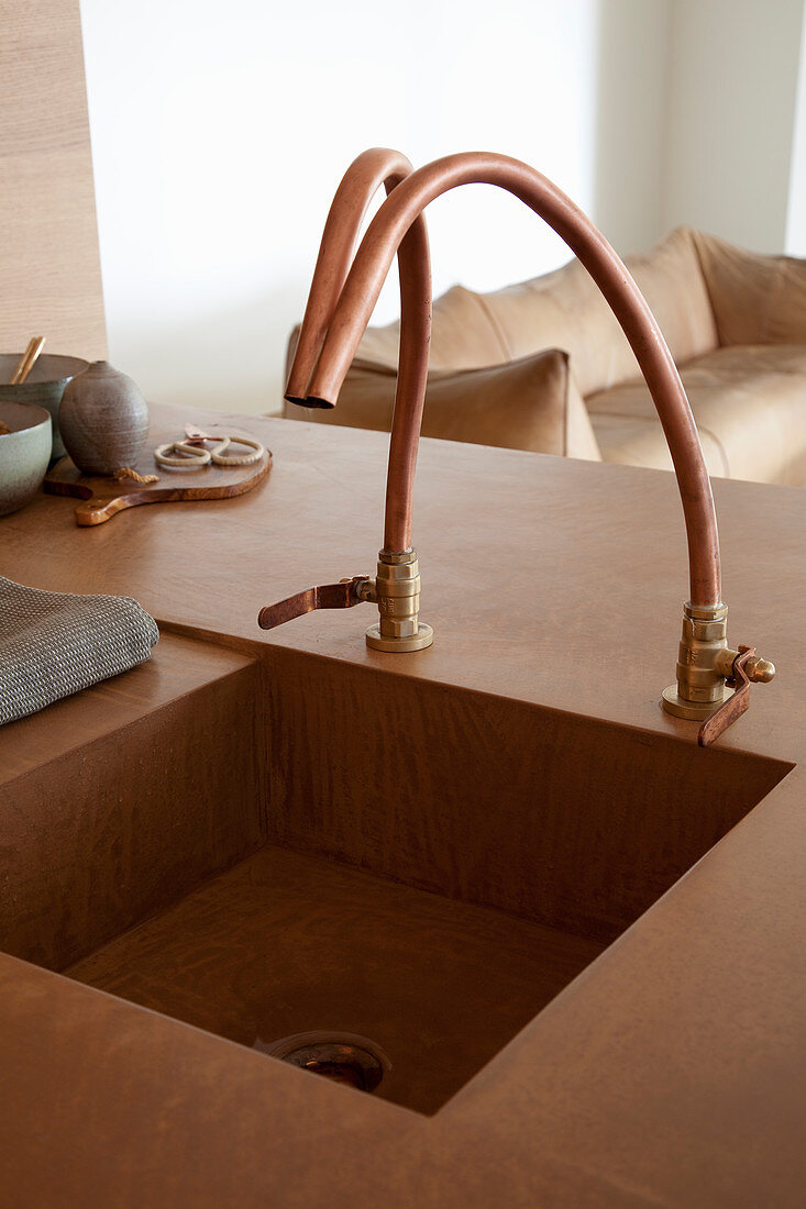 Designer sink with copper taps integrated in kitchen counter