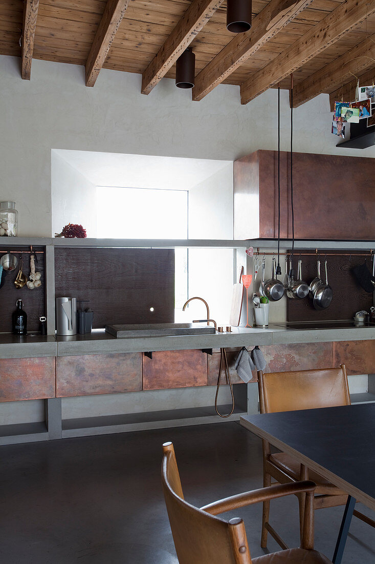 Industrial-style kitchen-dining room with rust-effect metal cupboards