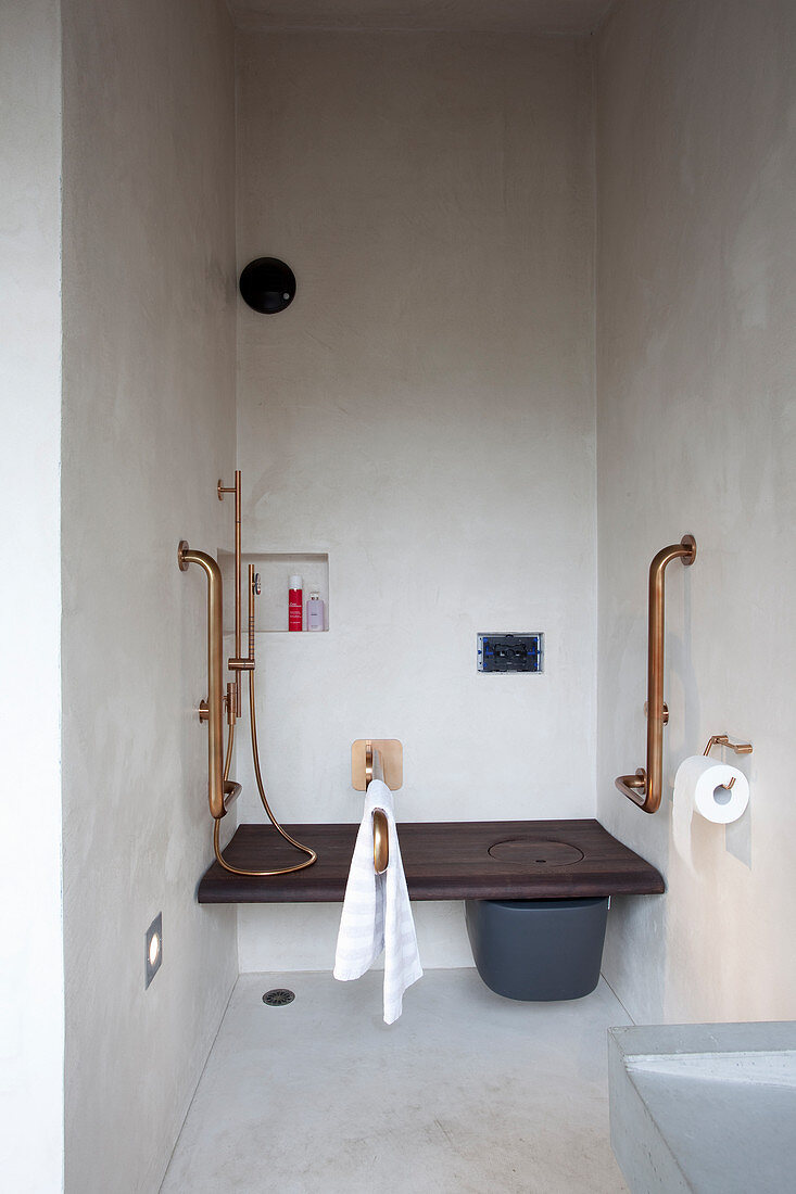 Toilet integrated into bench and bidet shower in narrow bathroom