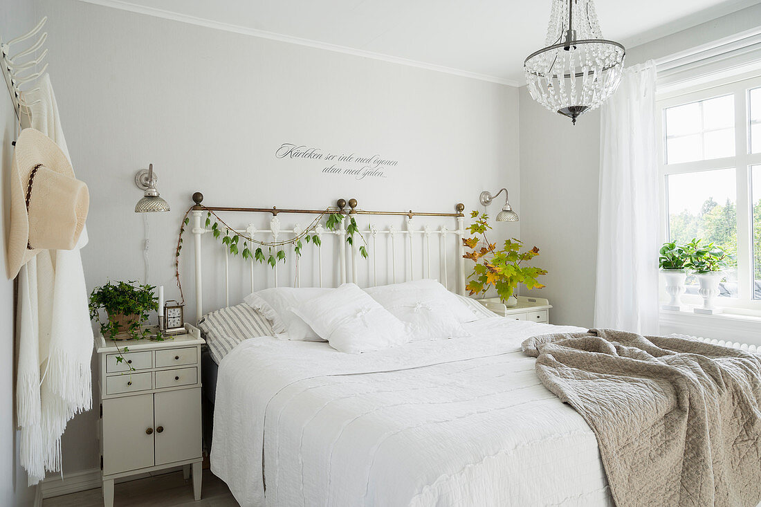 Nostalgisches Schlafzimmer in Weiß mit Wandtattoo über dem Bett