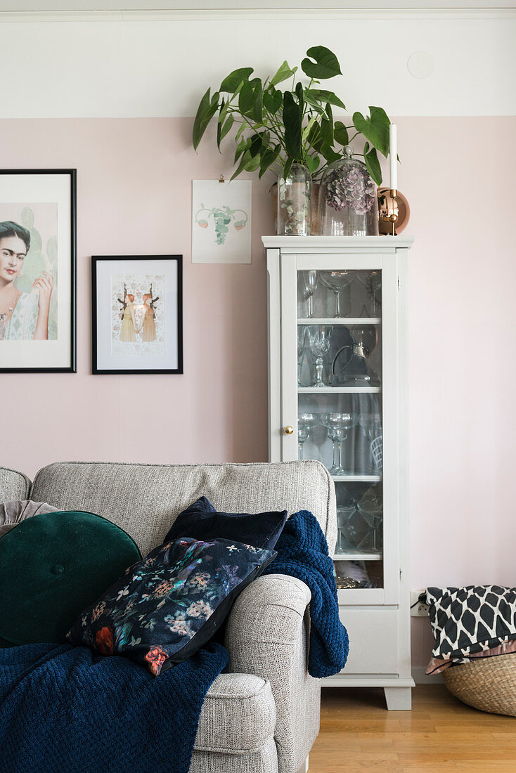 Zimmerpflanze auf einer Vitrine an rosafarbener Wand im Wohnzimmer