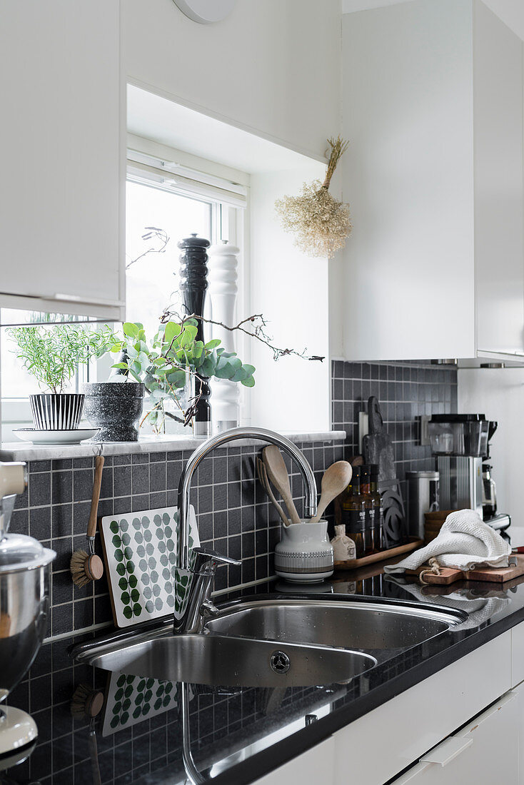weiße Küche mit schwarzem Fliesenspiegel