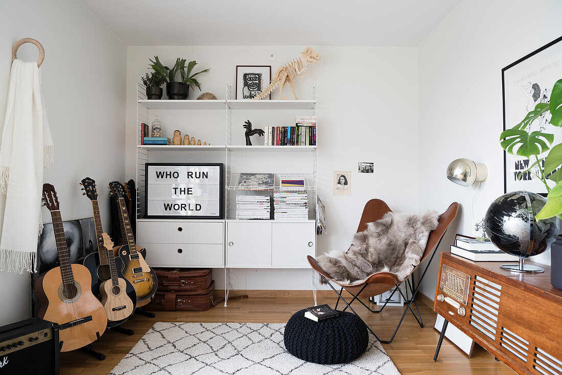 Guitar, white wall-mounted shelves, Butterfly chair and large phono sideboard in music room