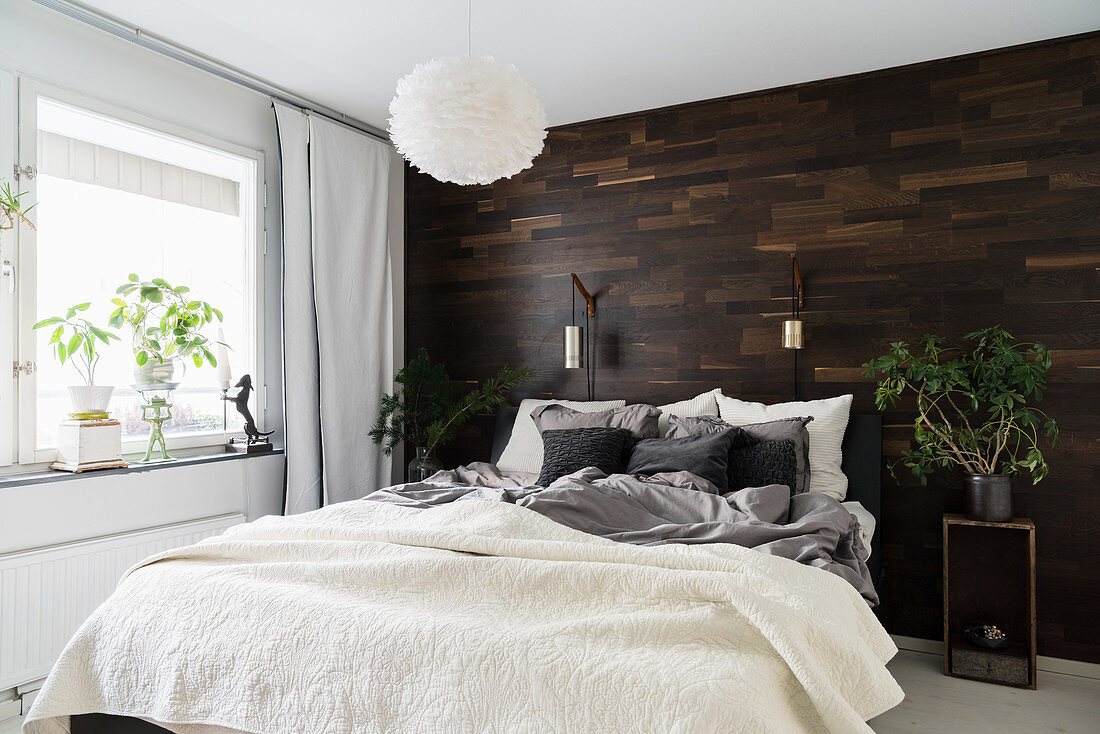 Mit dunklem Holz verkleidete Wand im winterlichen Schlafzimmer