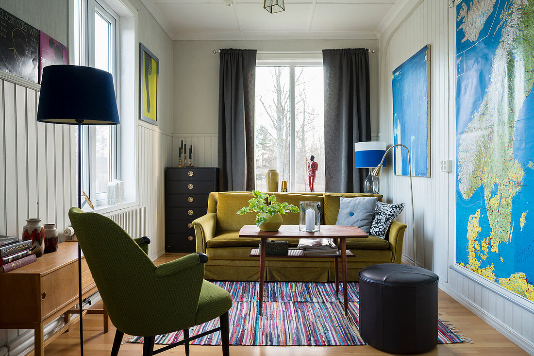 Kleines Wohnzimmer mit Wandverkleidung und grünem Sofa
