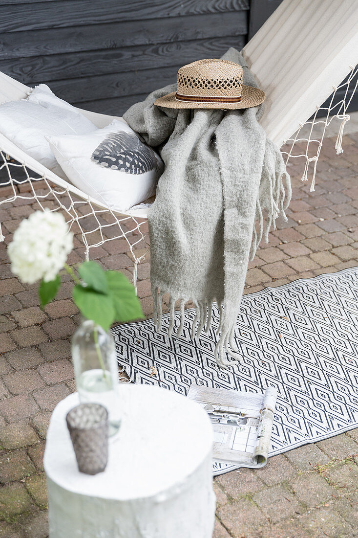 Cushion, blanket and hat on hammock on veranda