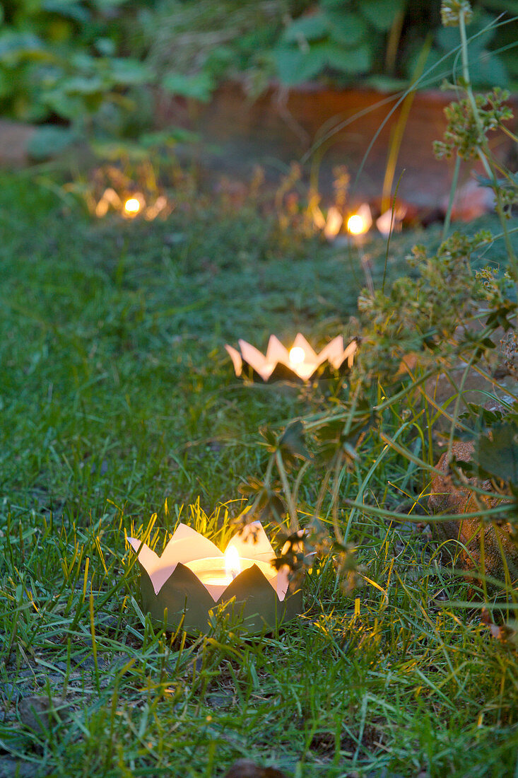 DIY-Krönchen-Windlichter aus Metalldosen am Gartenweg entlang