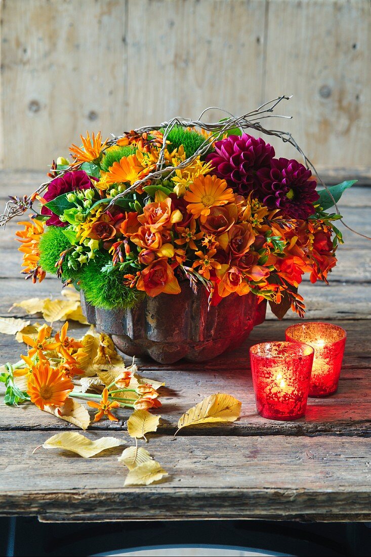 Herbstliches Gesteck mit Dahlien, Freesien, Ringelblumen und Asclepias