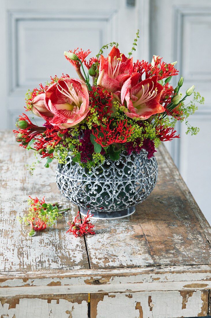 Rot-grüner Strauß aus Amaryllis, Frauenmantel, Korallenblumen, Eustoma (Prärieenzian) und Blüten von Sedum