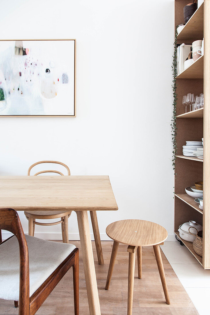Various wooden chairs and stool around simple dining table