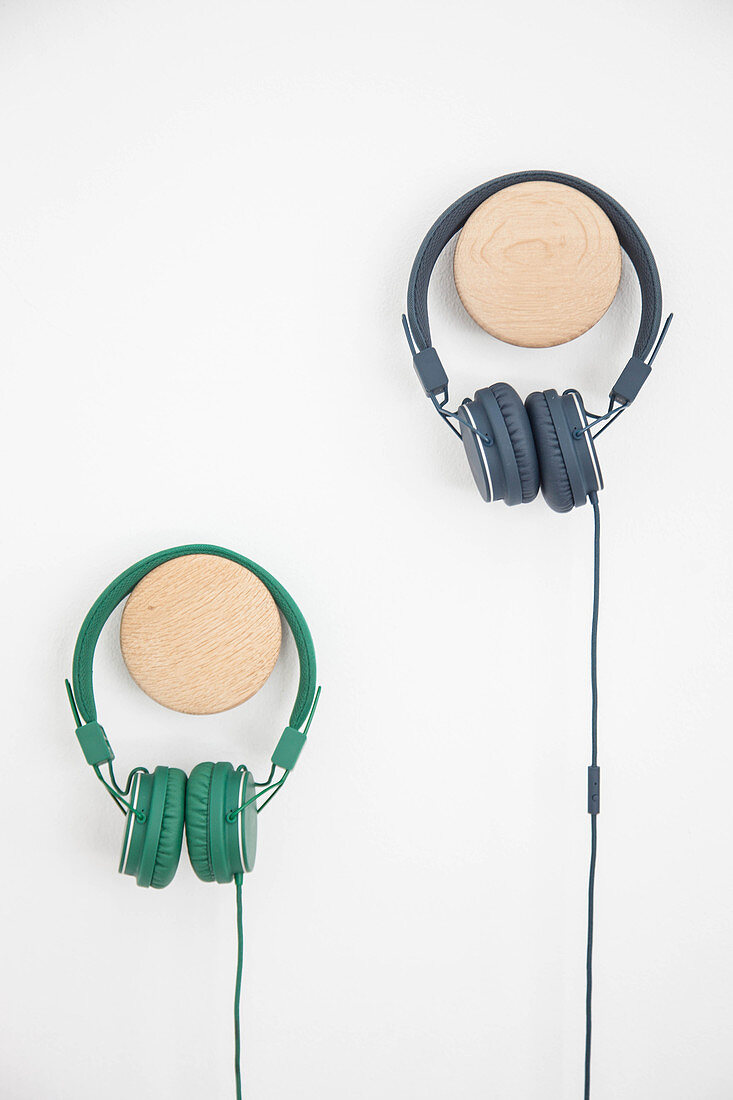 Headphones on wooden pegs on wall