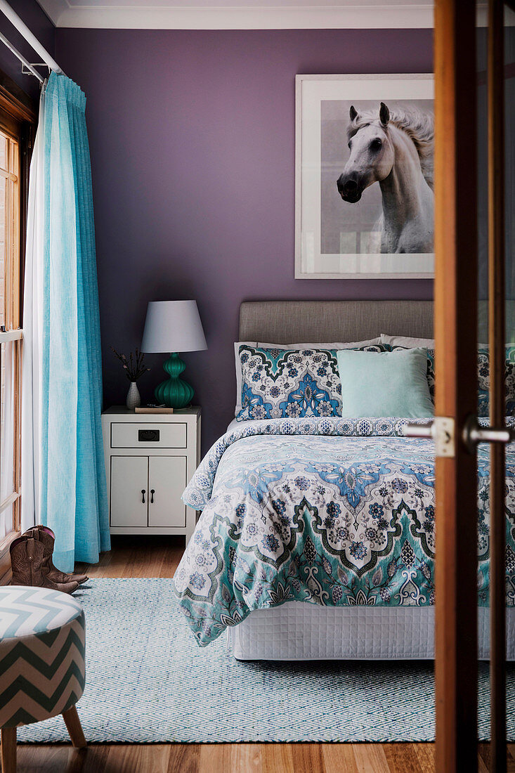 Pferdebild an lilafarbener Wand über dem Bett im Schlafzimmer