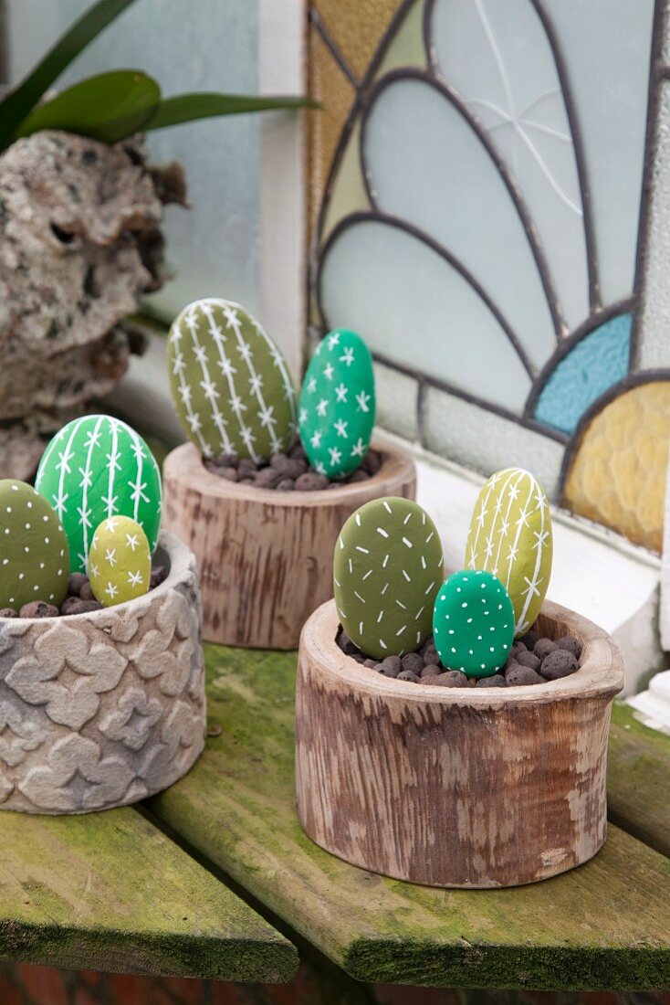 Decorative arrangement of pebbles painted to resemble cacti in pots