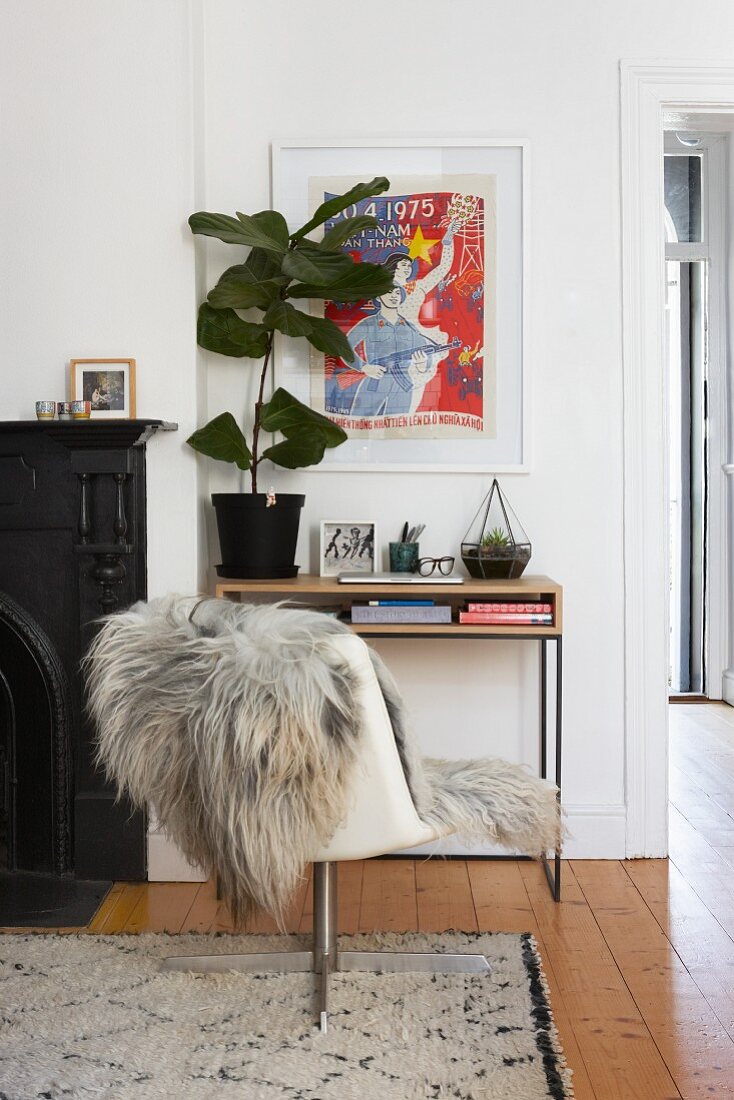 Drehstuhl mit Fell vor einem Konsolentisch mit Zimmerpflanze
