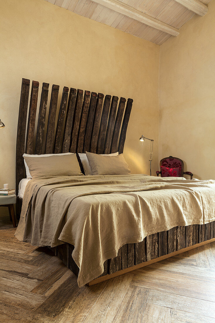 Double bed with headboard made from reclaimed wood in bedroom