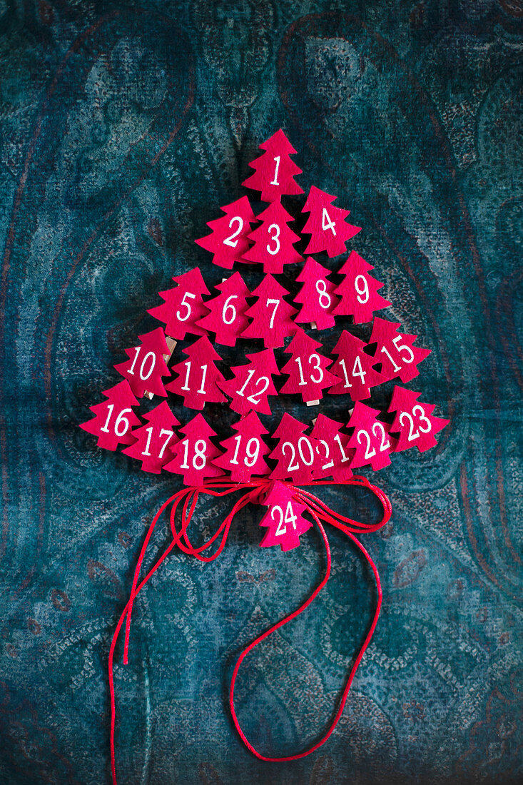 Small, numbered, felt trees arranged in the shape of a Christmas tree