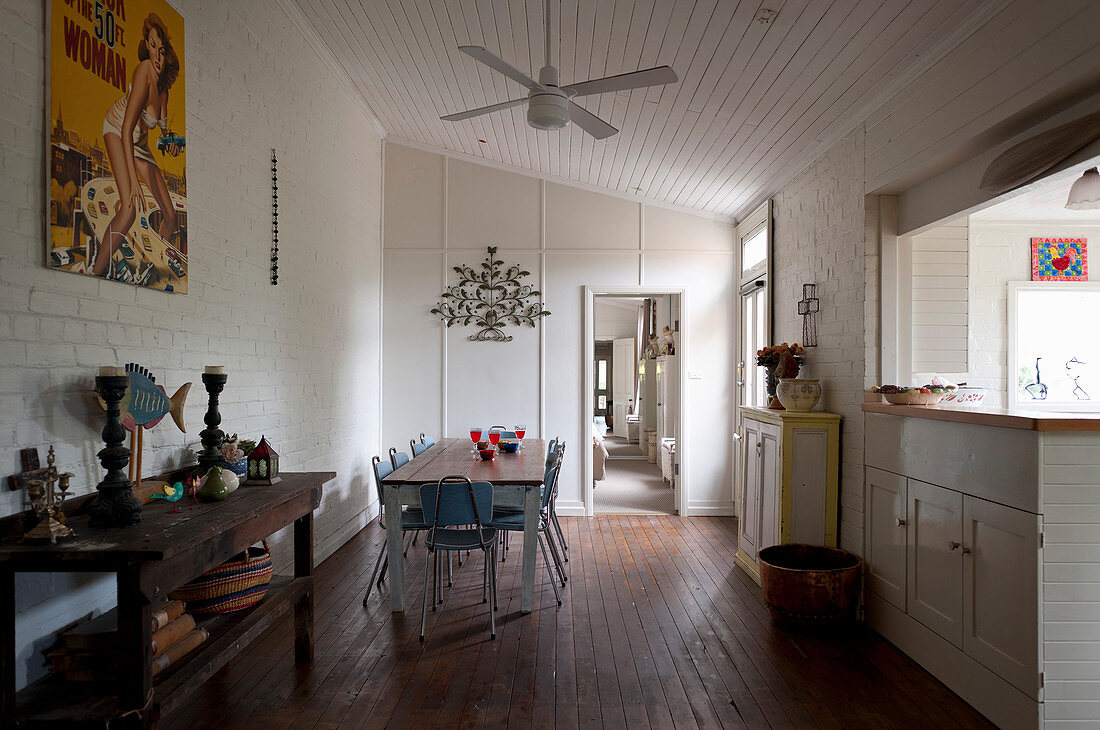 Rustikale Konsole und Essbereich vor Küchentheke im Raum mit weiß gestrichener Ziegelwand