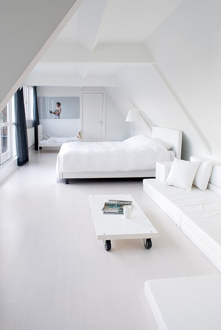 Minimalistisches Schlafzimmer in Weiß unter der Dachschräge