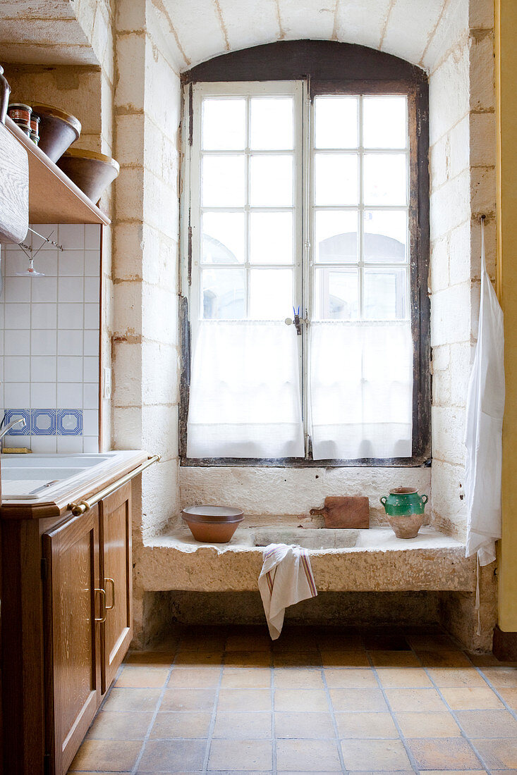 Hohes Sporssenfenster in rustikaler Landhausküche mit Spülstein