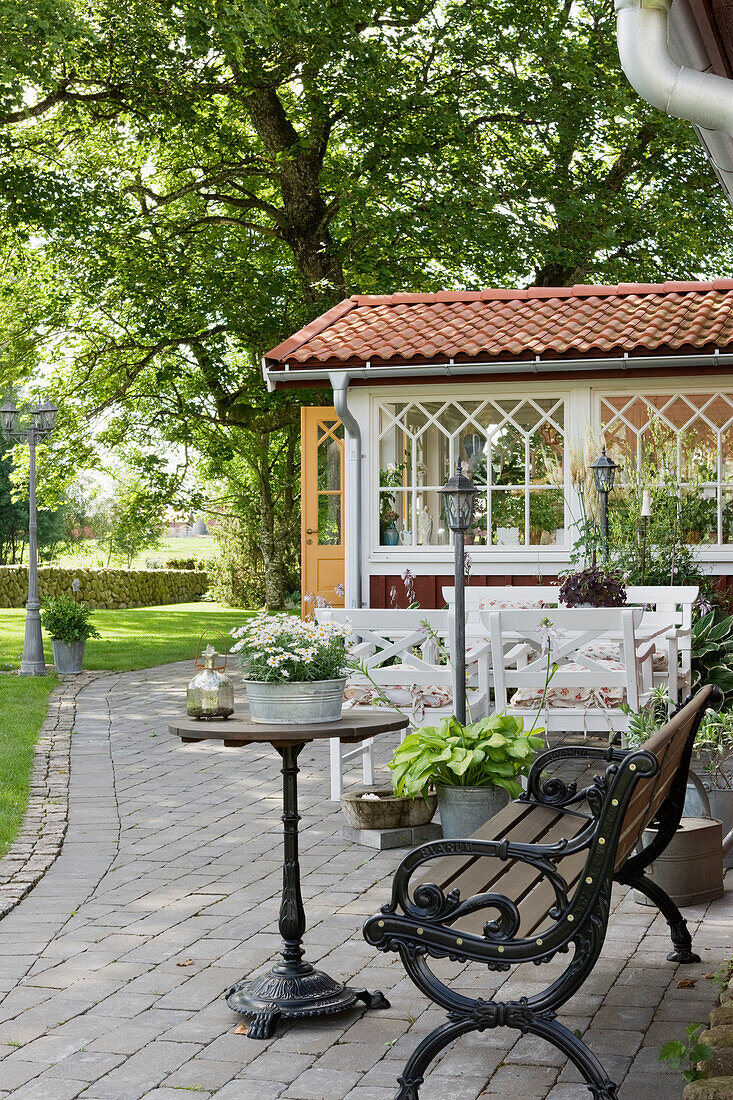 Terrassenplatz mit Gartenbank und rundem Tisch