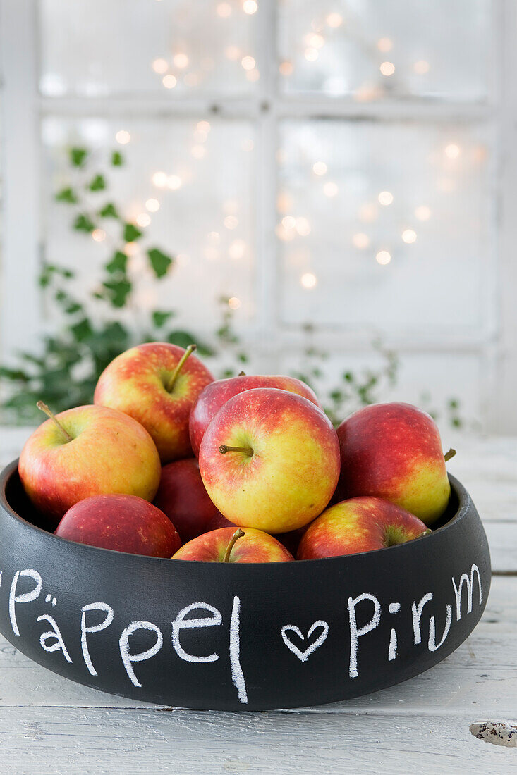 Black chalkboard painted wooden bowl with apples