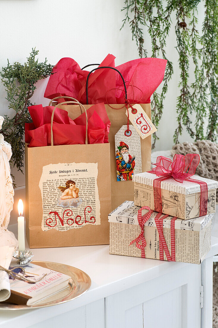 Weihnachtlich dekorierte Geschenktüten und mit alten Buchseiten beklebte Geschenkschachteln