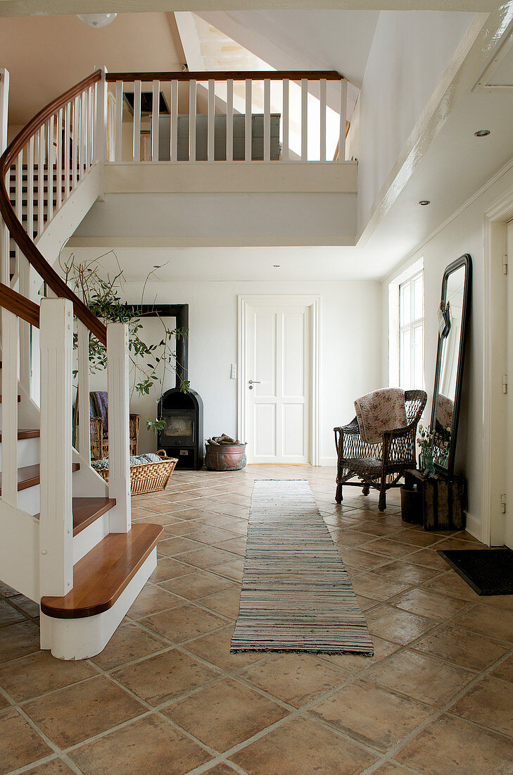 Winding staircase in classic entrance hall with brown floor tiles