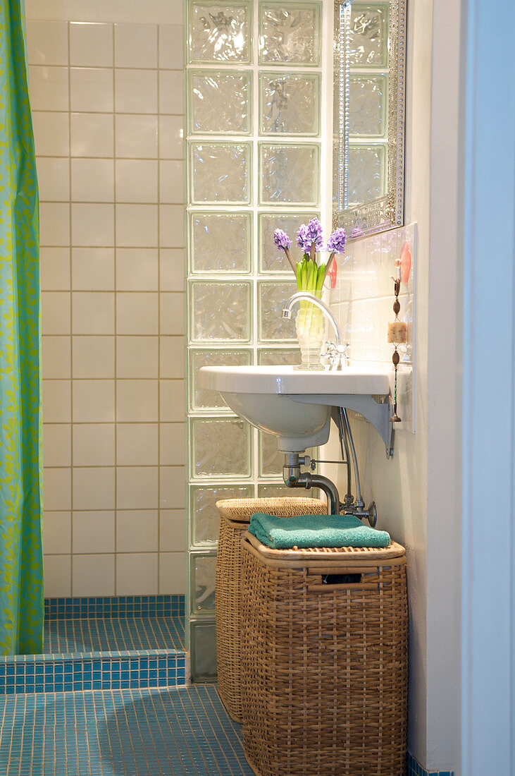 Wäschekörbe unterm Waschbecken vor der Dusche mit Glasbausteinen