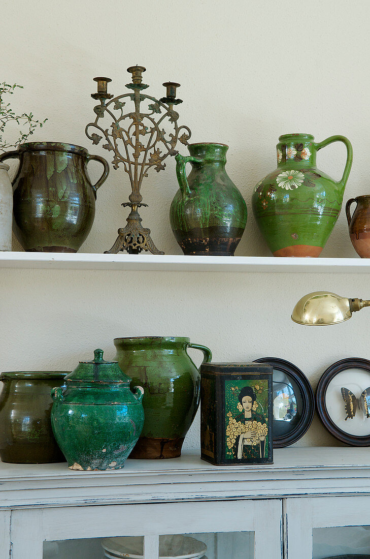 Collection of old clay pitchers and vases in shades of green as decoration