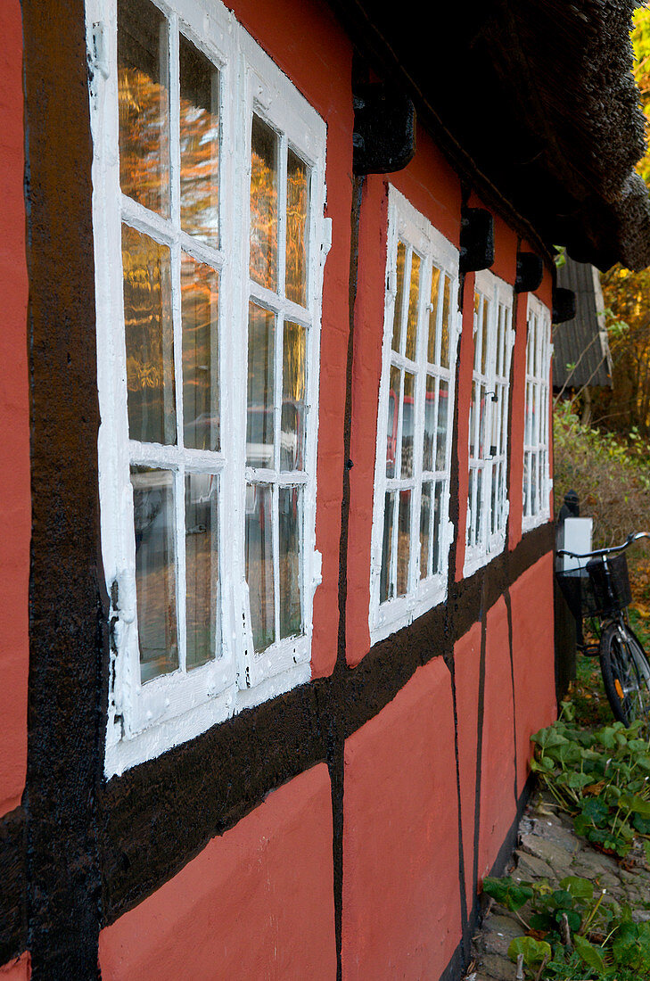 Red half-timbered house with lattice windows in autumn