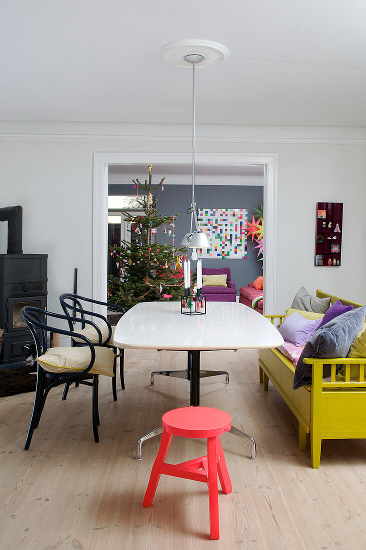 Stilmix im Esszimmer mit gelber Küchenbank und Blick ins Wohnzimmer
