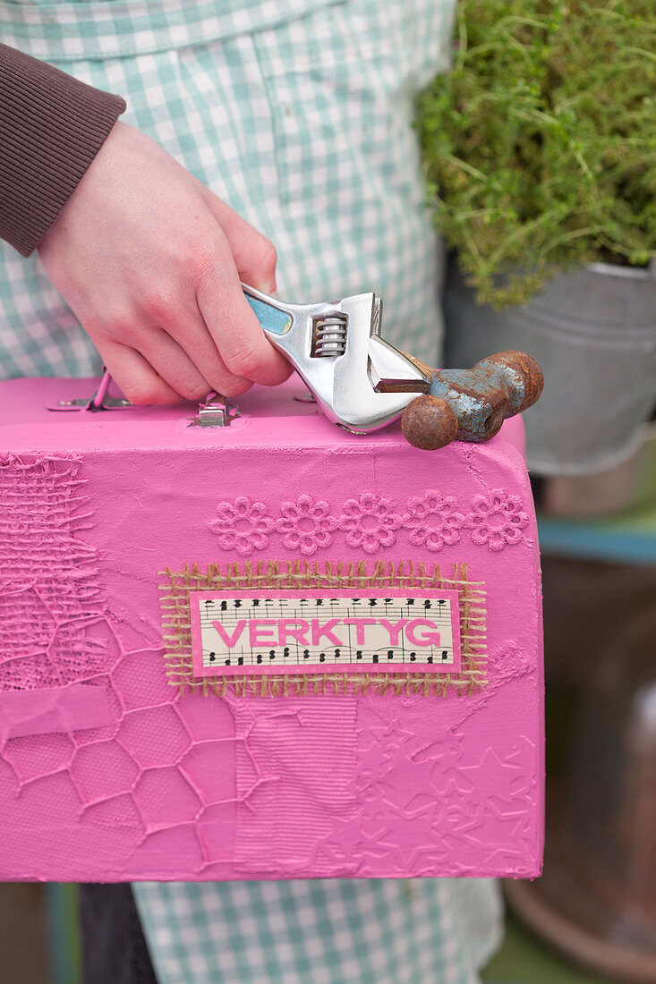 Pink, handmade tool box being carried