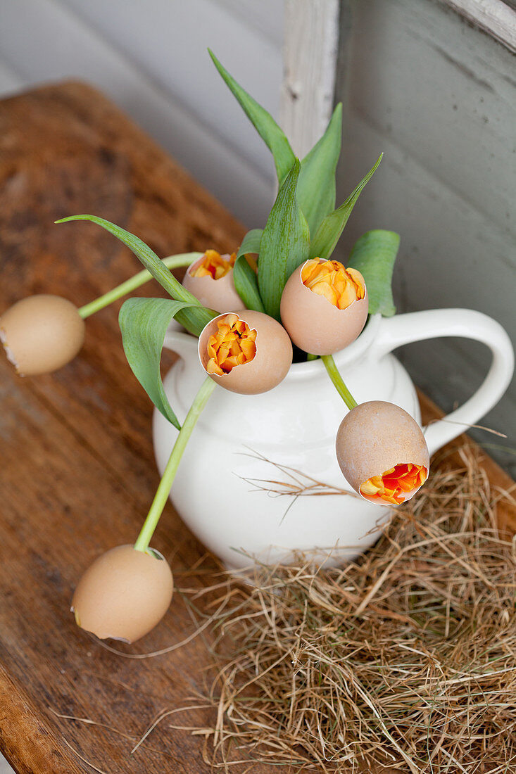 Über Tulpen gestülpte Eierschalen, Blumenstrauß im Krug