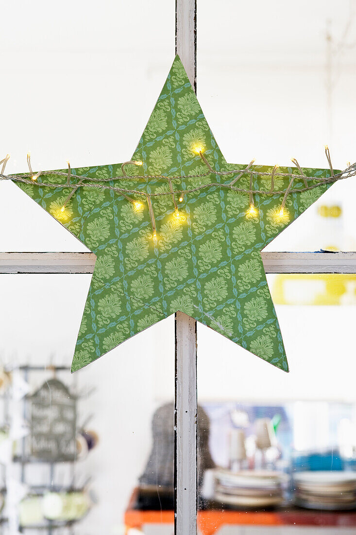 DIY-Stern aus Sperrholz und Geschenkpapier mit Lichterkette umwickelt