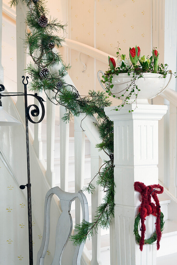 Weihnachtsgirlande und Blumenschale mit Amaryllis als Treppendekoration