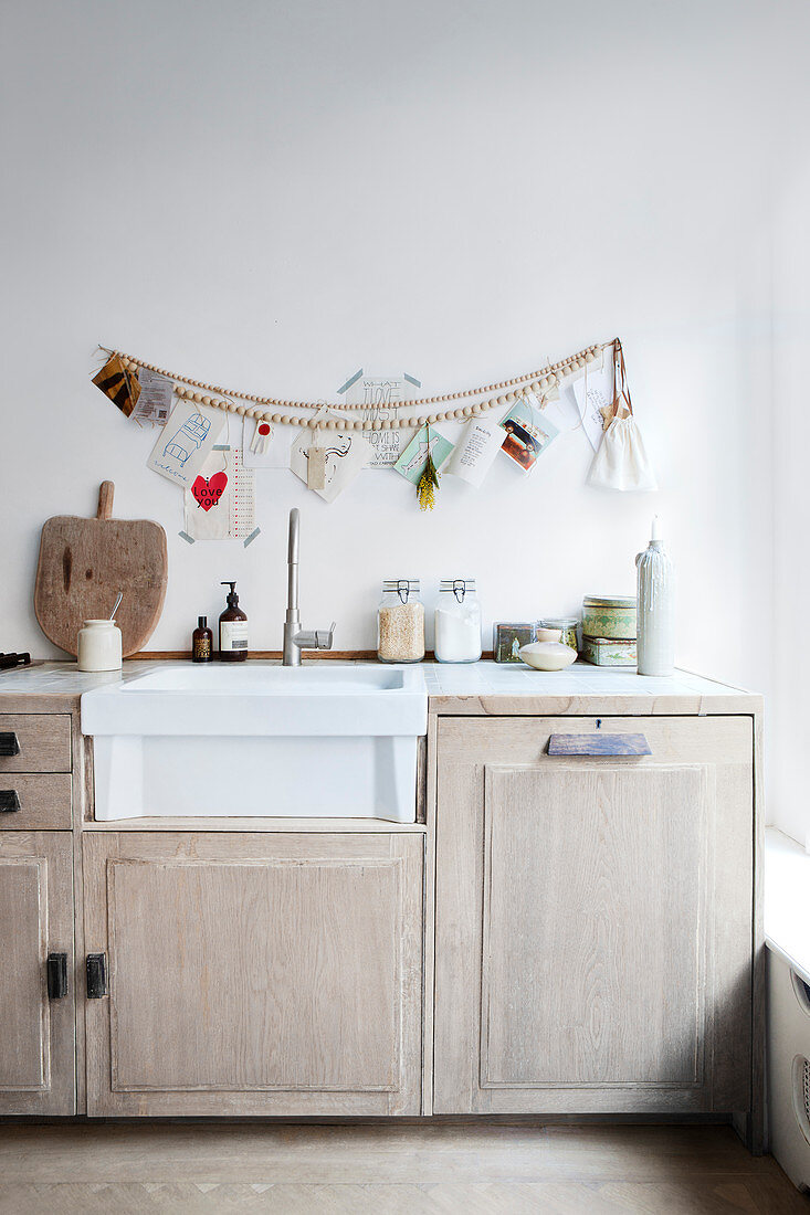 Holzperlenkette und Grußkarten über Küchenzeile mit Spülbecken