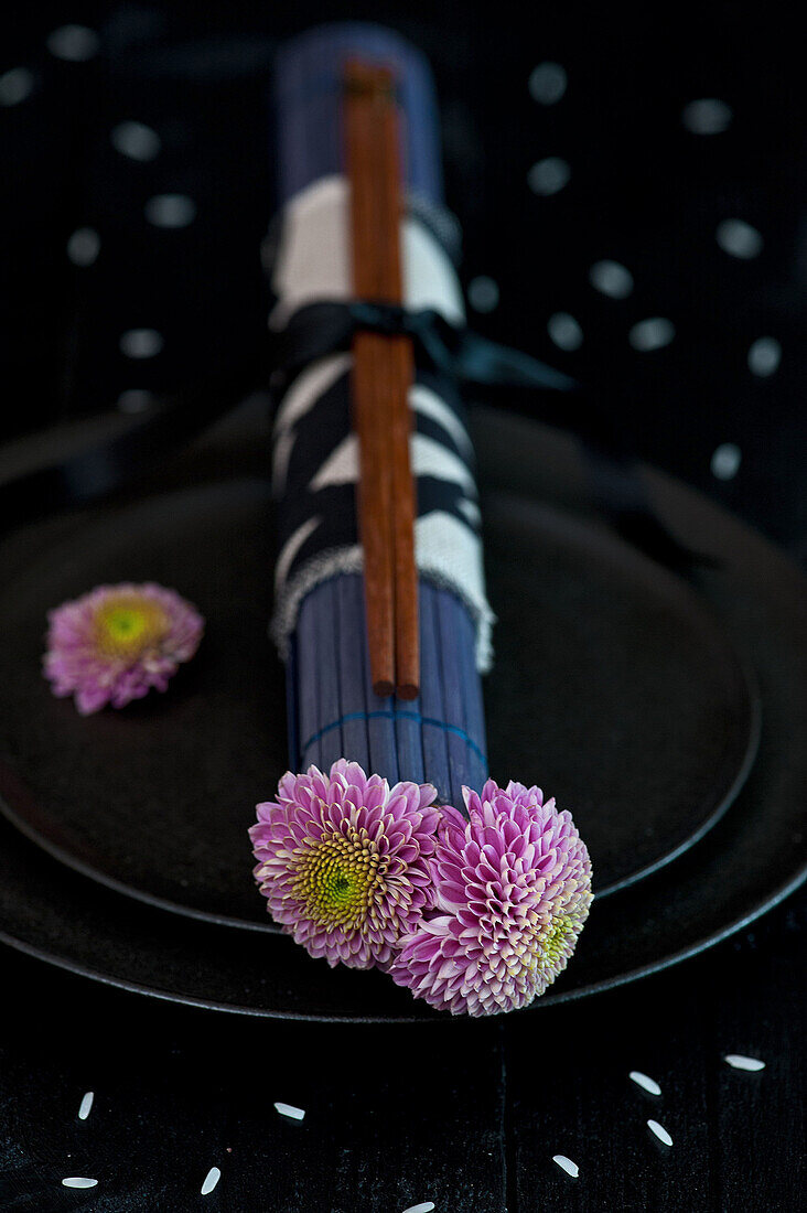 Black plate with chopsticks and chrysanthemums (Chrysanthemum)