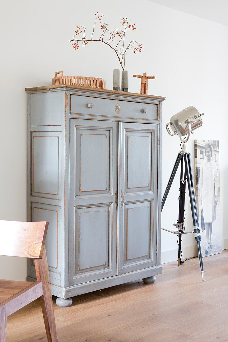 Old gray cupboard with wainscotting doors with simple decorations