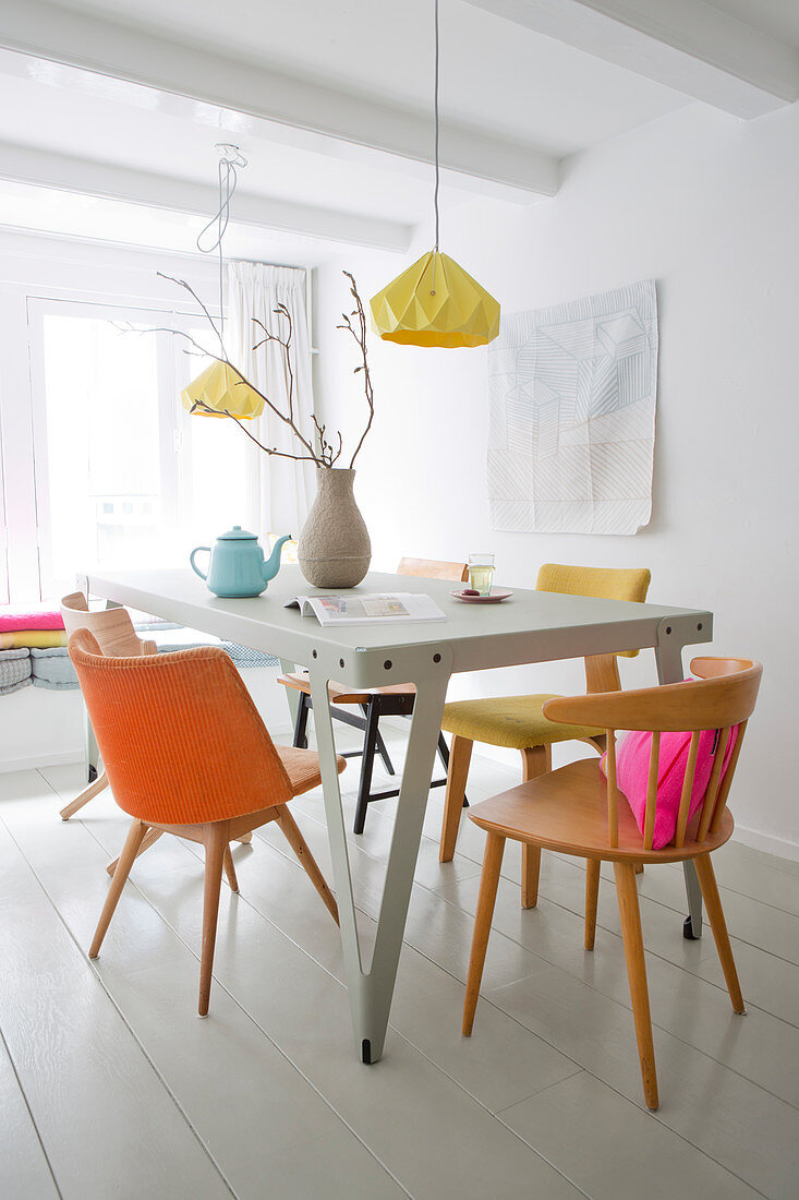 Metal table and various chairs in pastel shades